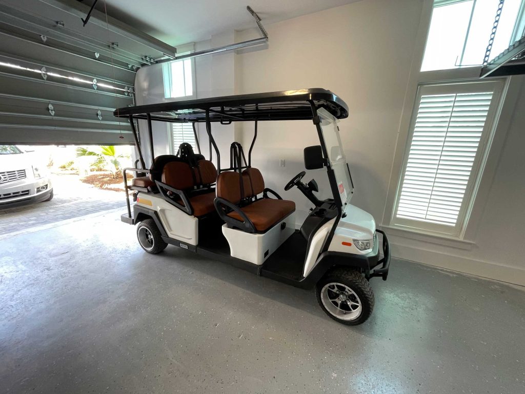 A street legal six-seater golf cart safely stored in a garage.